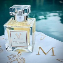 Load image into Gallery viewer, Perfume bottle labeled 'Ever Present' by 'Marbella' on a blurred water background